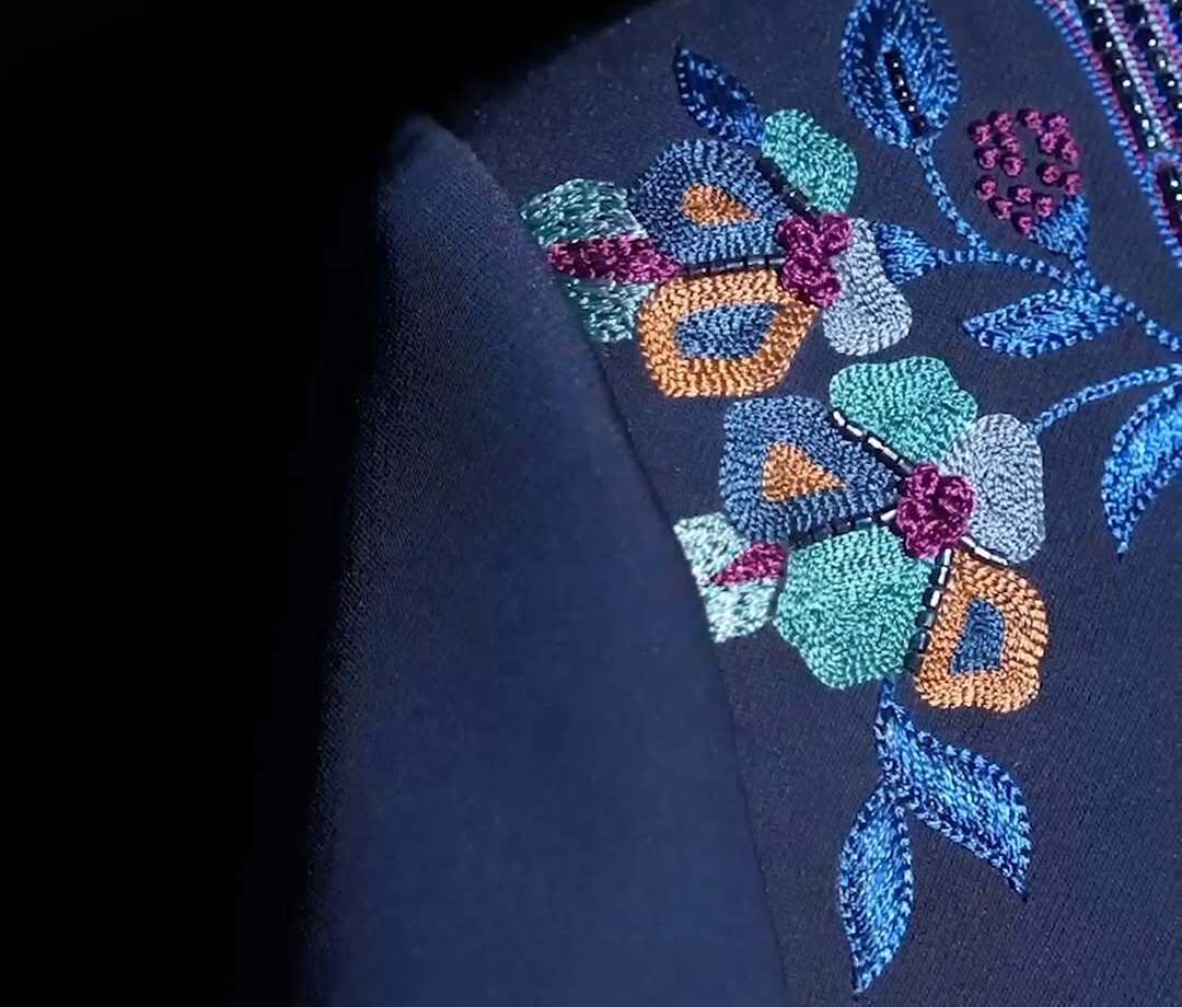 Multicoloured floral hand embroidery on a navy garment